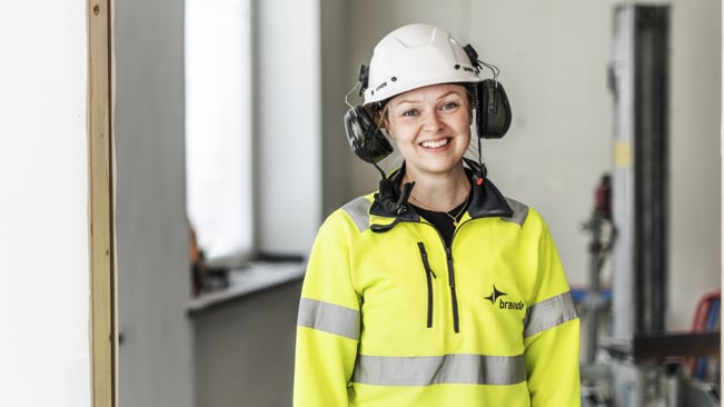Leende ung elektriker på ett bygge