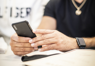 Två händer som håller i en mobiltelefon