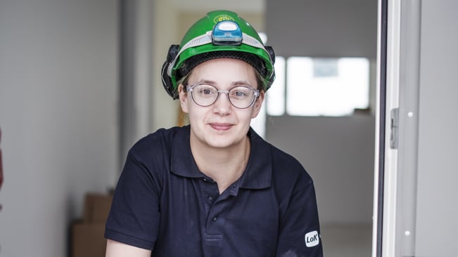 Leende ung elektriker på ett bygge